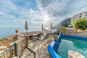 a swimming pool next to the ocean next to a building at Vila Dora in Dobra Voda