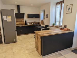 a large room with a kitchen with a counter top at L'ecole buissonnière in Riaucourt