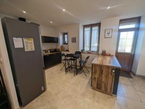 a kitchen with a table and chairs in a room at L'ecole buissonnière in Riaucourt