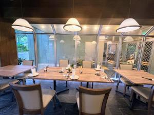 a dining room with wooden tables and chairs at Pension Puutaro in Zaō Onsen