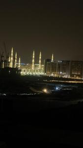 a city lit up at night with buildings in the background at صالة المدينة 2 in Medina