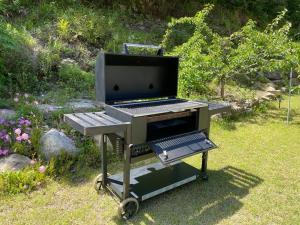 a barbecue grill sitting in the grass in a garden at Yangyang Dalpaengi Pension in Yangyang +5 photos