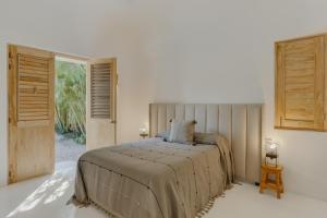 a bedroom with a bed and a large window at Casa Brasil Careyes in Careyes