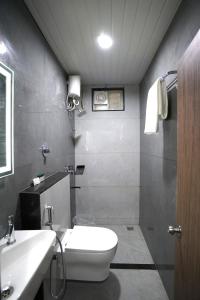 a bathroom with a white toilet and a sink at TheCloud Hotel in Nizāmābād +14 photos