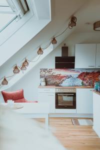 a kitchen with white counters and a staircase with lights at RheinStrand, wunderschöne, renovierte Wohnung in Dormagen