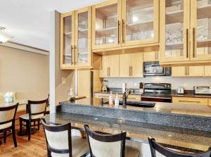a kitchen with wooden cabinets and a counter top at Crestview Place Mountain View Balcony & Shuttle in Winter Park