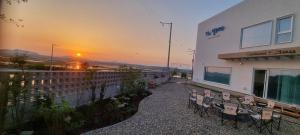 a patio with chairs and a building with a sunset in the background at Paju Seolreda in Paju