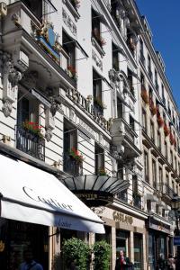 パリにあるHotel Westminsterの白い高い建物で、窓に花箱が設置されています。