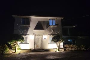 ein weißes Haus mit einer weißen Tür bei Nacht in der Unterkunft Midae Oppa in Geoje