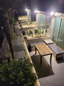 eine Terrasse mit Bänken, einem Tisch und Pflanzen in der Unterkunft Midae Oppa in Geoje