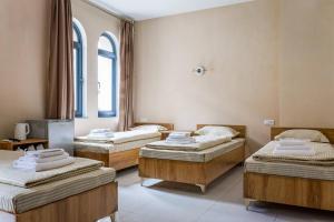 a group of three beds in a room at Olchazor hotel in Tashkent