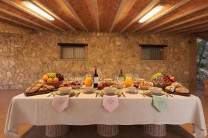 a table with food and fruits and bottles of wine at Masia Garriga in Tarragona