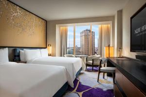 a hotel room with two beds and a television at Caesars New Orleans, A Caesars Rewards Destination in New Orleans +84 photos