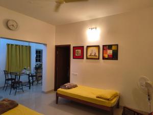 a room with two beds and a dining room with a table at Athreyas@60/A in Mysore +13 photos