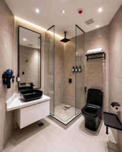 a bathroom with a shower and a toilet and a sink at Hotel Arkam in San Salvador +18 photos
