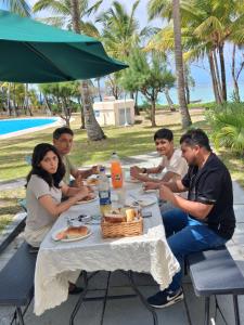 a group of people sitting around a table with food at 23 Residence Thalassa, in Belle Mare