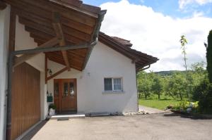 a small white house with a wooden door at Auszeitloge in Nottwil