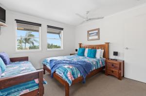 a bedroom with two beds and two windows at Villa 31 Tangalooma Beach Front in Tangalooma