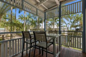 a screened porch with chairs and a table at Villa 31 Tangalooma Beach Front in Tangalooma