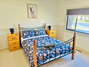 a bedroom with a bed and a window at Wombat Cottage Albury in Albury