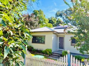 a white house with a white picket fence at Wombat Cottage Albury in Albury