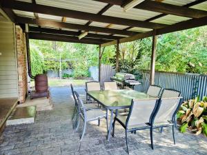 a patio with a table and chairs under a pergola at Wombat Cottage Albury in Albury