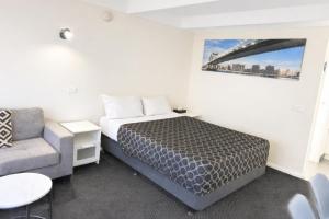a small bedroom with a bed and a couch at Charles Sturt Motor Inn in West Wyalong +31 photos