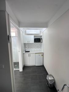 a small kitchen with white cabinets and a microwave at Charles Sturt Motor Inn in West Wyalong