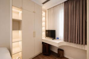 a bedroom with a desk with a tv and a window at Jade Boutique Hotel in Hanoi