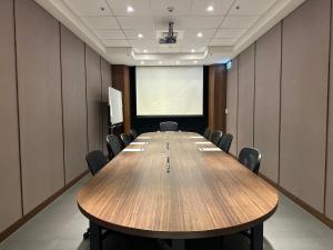 a conference room with a large wooden table and chairs at Just Palace Hotel in Taipei