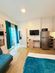 a room with a bed and a refrigerator in it at Antara Residential Condominium in Talisay