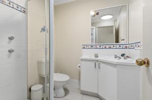 a bathroom with a toilet and a sink and a shower at Quandamooka Beach House in Bulwer +22 photos