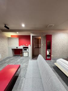 a living room with a couch and a kitchen at Hotel JOYCE in Saijō-chō