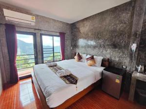 a bedroom with a large bed with a large window at 101 Tea Green View in Mae Salong