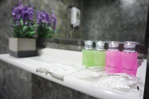 a bathroom shelf with bottles of detergent and flowers at 101 Tea Green View in Mae Salong