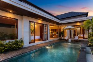 a villa with a swimming pool and a house at Denaya Villa in Ubud
