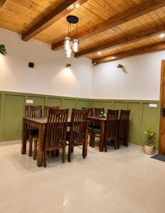 a dining room with wooden tables and chairs at The Alpine Escape, Manali - A Beautiful Cottage in Cloud's in Manāli
