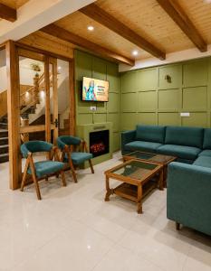 a living room with a couch and chairs and a fireplace at The Alpine Escape, Manali - A Beautiful Cottage in Cloud's in Manāli