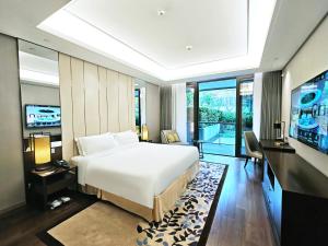 a bedroom with a large white bed and a television at Ascott Heng Shan Shanghai in Shanghai +76 photos