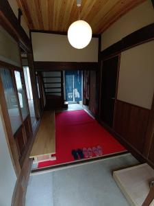 an empty room with two pairs of shoes on a red carpet at 大宇陀souw創 in Uda