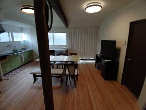 a living room with a dining room table and a kitchen at 大宇陀souw創 in Uda