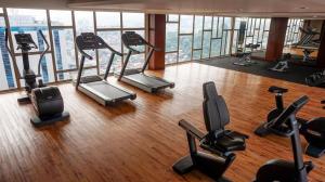 a gym with treadmills and exercise equipment in a building at Louis Kienne Hotel Pandanaran in Semarang