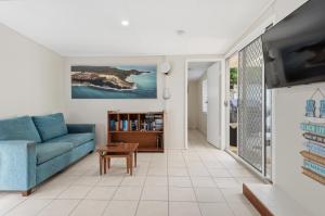 a living room with a blue couch and a table at Curlew Corner in Cowan Cowan