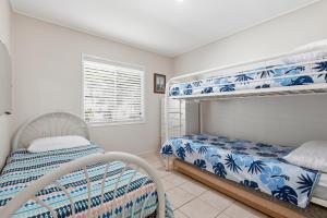a bedroom with two bunk beds and a window at Curlew Corner in Cowan Cowan