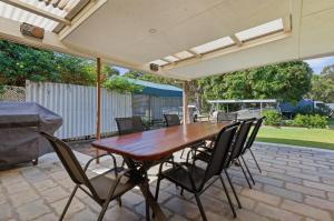 a wooden table and chairs on a patio at Curlew Corner in Cowan Cowan