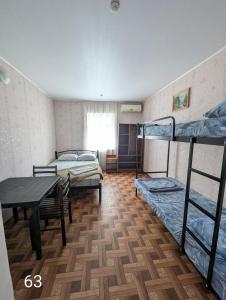 a room with two bunk beds and a table at Золотий Якір in Gribovka