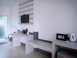 a room with two benches and a tv on the wall at The Key Hotel in Ko Lipe