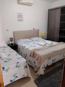 a bedroom with two beds and a sign on the wall at Casa Grande com 4 camas, 2 Quartos com AR CONDICIONADO nos dois quartos in Juazeiro do Norte