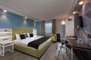 a hotel room with a bed and a desk at Peine Salzgitter Hotel by Belvilla in Peine +30 photos