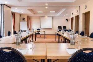 a conference room with long tables and chairs and a whiteboard at Peine Salzgitter Hotel by Belvilla in Peine